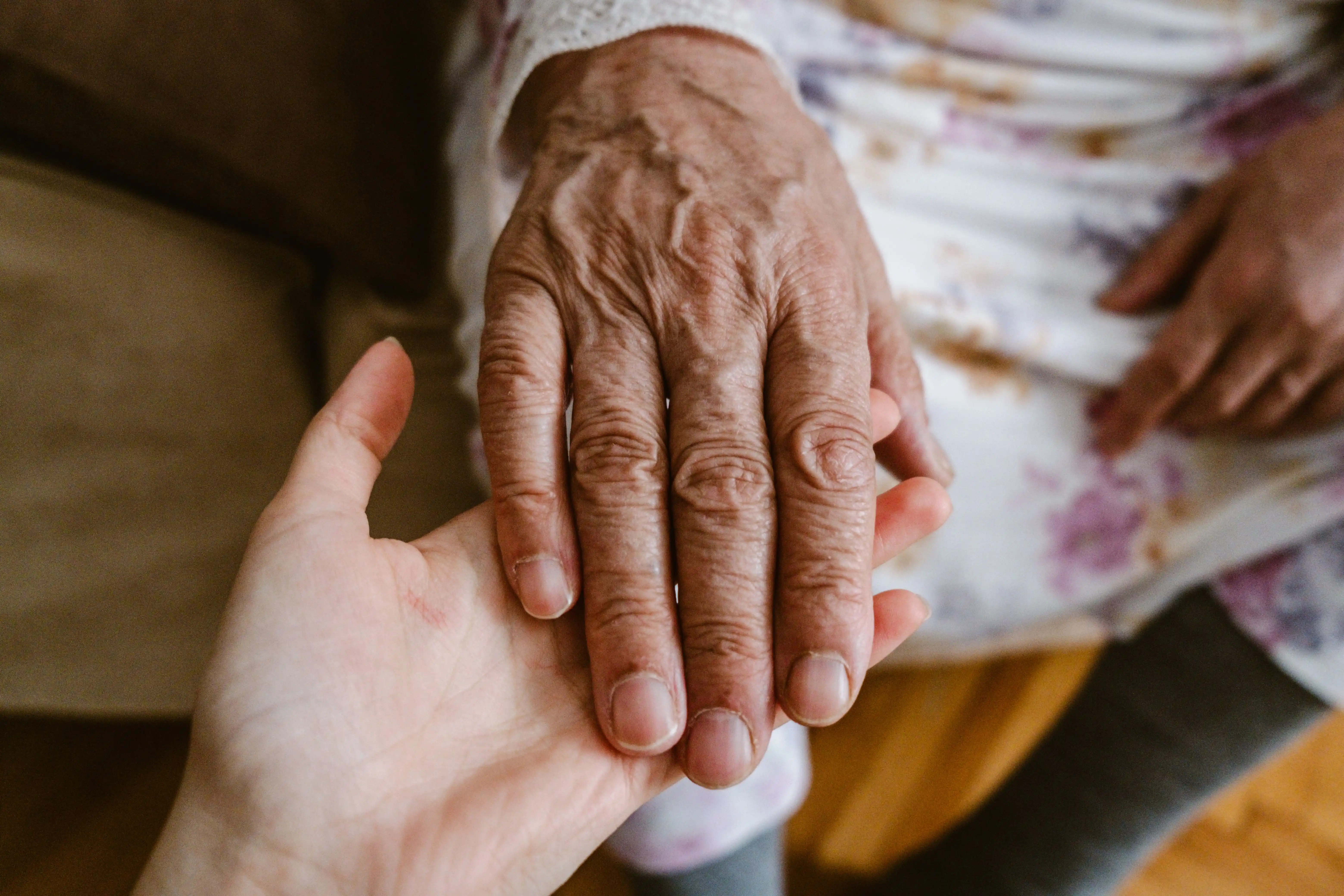 Karriere bei Pflegedienst Sofia – Pflegerin hält die Hand eines Patienten